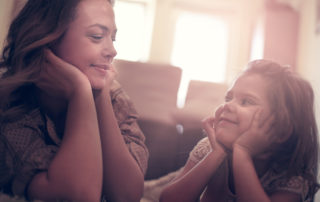 Mother and young girl smiling at each other